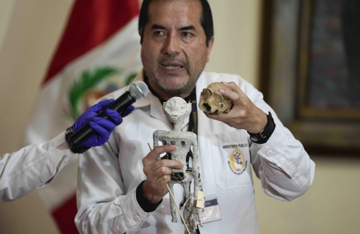 Forensic archaeologist Flavio Estrada from Peru's prosecutor's office shows a doll, which was seized by authorities before it was shipped to Mexico, during a press conference to explain what it is made of at the Archeology Museum in Lima, Peru, Friday, Jan. 12, 2024. According to Estrada, two dolls and a three-fingered hand are constructed of paper, glue, metal, human and animal bones.