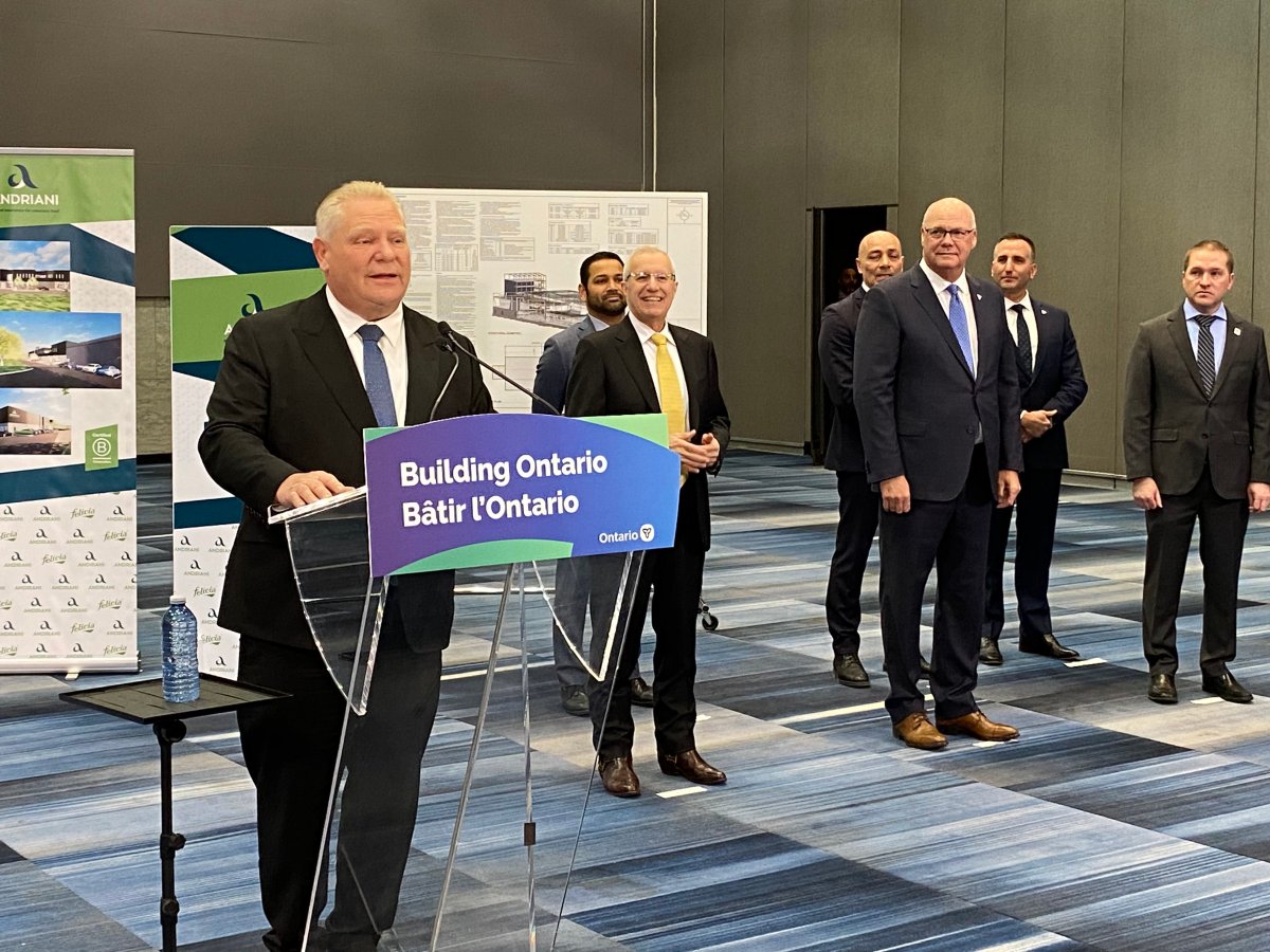 Premier Doug Ford standing at a clear podium in front of poster boards in a hotel conference room.